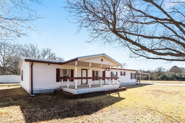 a front view of a house with garden and sitting area