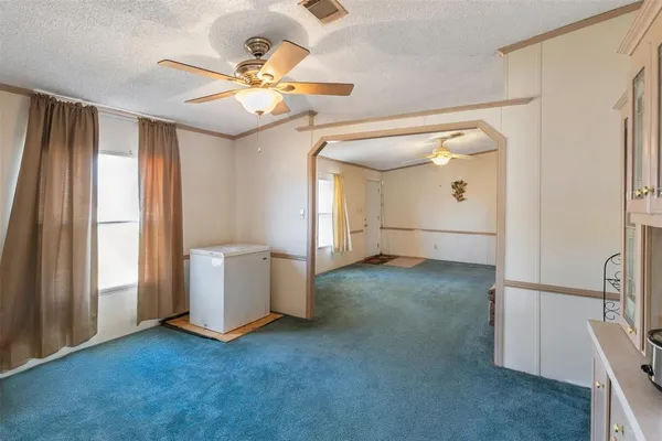 an empty room with windows and fan