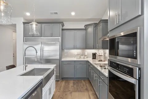 a kitchen with a sink stove top oven and refrigerator