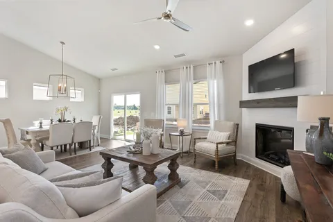 a living room with furniture a fireplace and a flat screen tv
