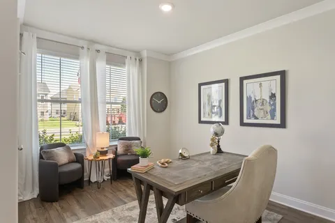 a view of a workspace with furniture and a window