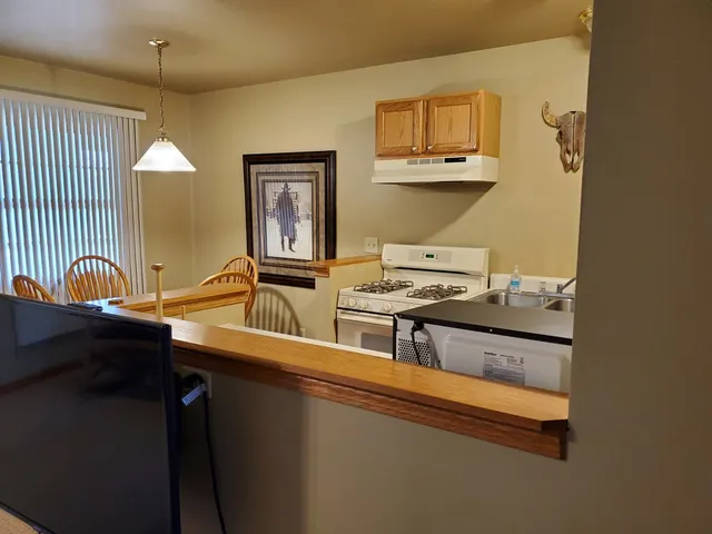 a kitchen with stainless steel appliances granite countertop a sink stove and cabinets