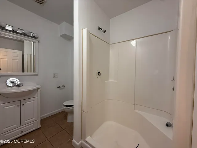 a bathroom with a shower a toilet and a sink