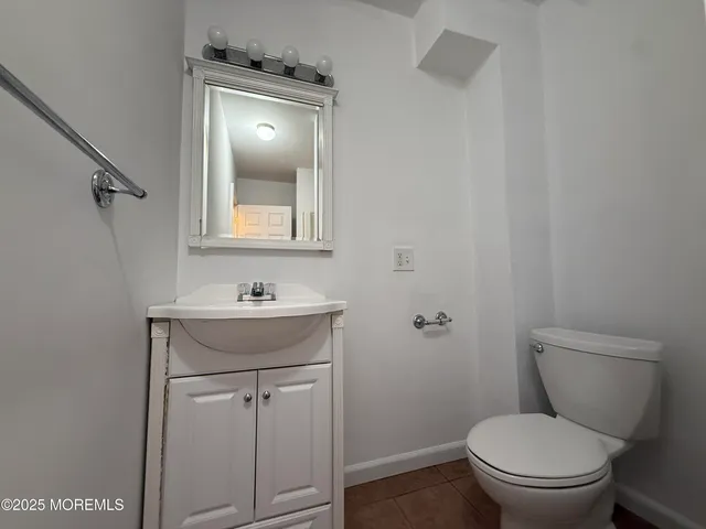 a bathroom with a toilet a sink and mirror