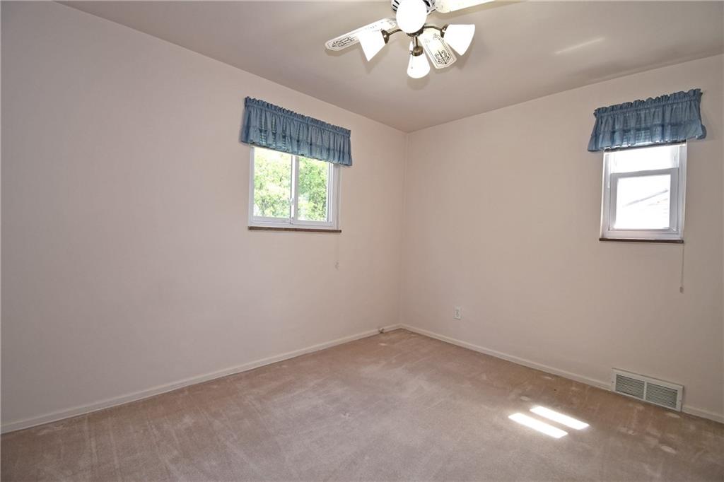 801 Highview Road Pittsburgh, PA 15234 - Photo 17 of 30 an empty room with a chandelier fan and windows