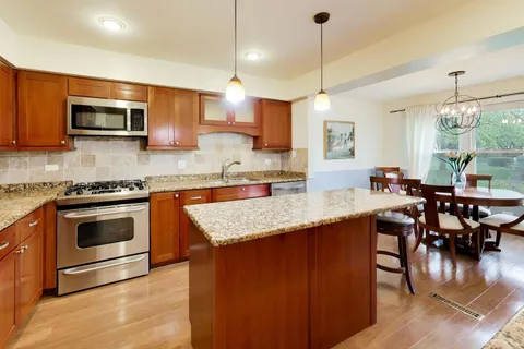 a kitchen with stainless steel appliances granite countertop a stove a sink and a microwave