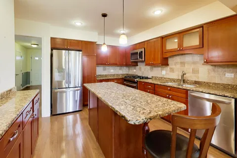 a kitchen with stainless steel appliances granite countertop a sink stove and refrigerator