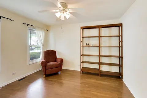 a living room with furniture a ceiling fan and a window