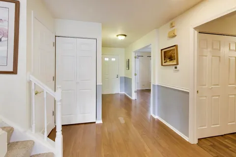 a view of a hallway with wooden floor and entryway