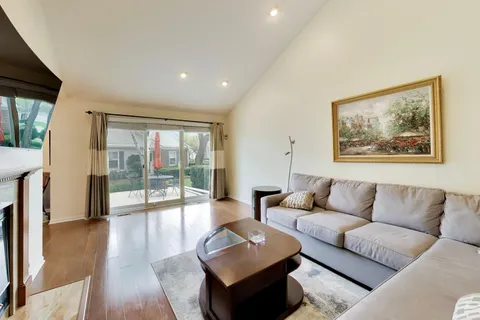 a living room with furniture and a large window with wooden floor