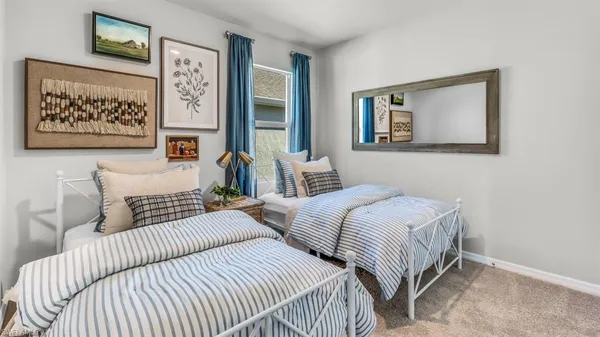 a bedroom with two beds and painting on the wall