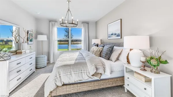 a spacious bedroom with a bed a dresser and potted plant