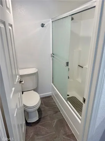 a white toilet sitting next to a bath tub
