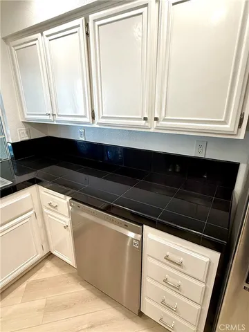 a view of a refrigerator in kitchen and an empty room