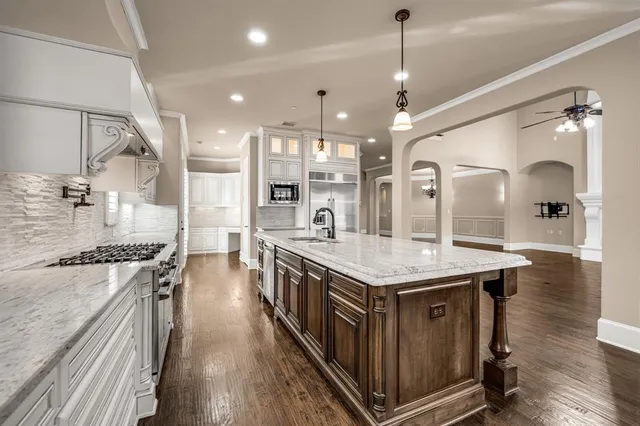 a kitchen with stainless steel appliances granite countertop a sink stove and cabinets