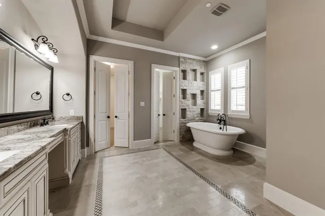 a large spacious bathroom with a double vanity sink a large mirror and a bathtub