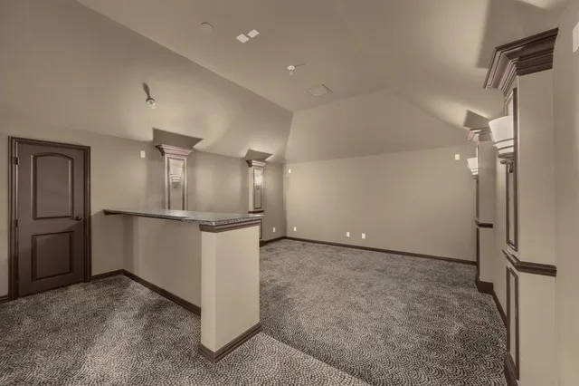 a view of a refrigerator in kitchen and an empty room