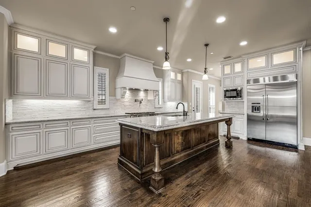 a kitchen with stainless steel appliances granite countertop a sink a stove and a refrigerator