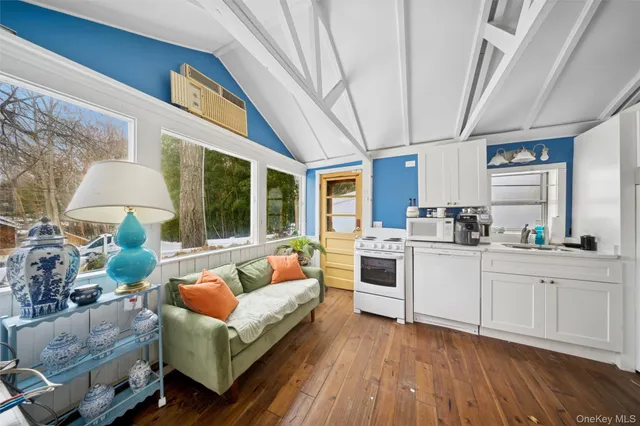 a living room with stainless steel appliances furniture and a large window