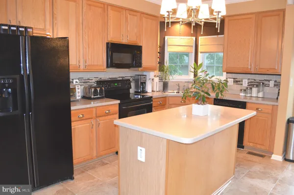 a kitchen with stainless steel appliances granite countertop a sink a stove and a refrigerator
