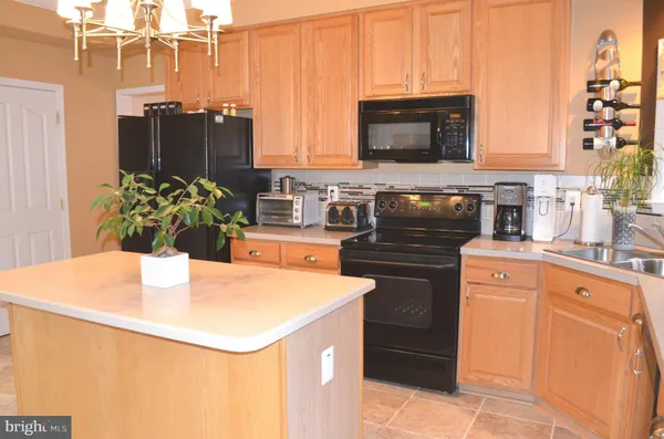 a kitchen with stainless steel appliances kitchen island wooden cabinets a stove and a refrigerator