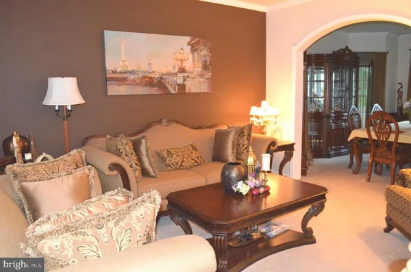 a living room with furniture and a painting on the wall