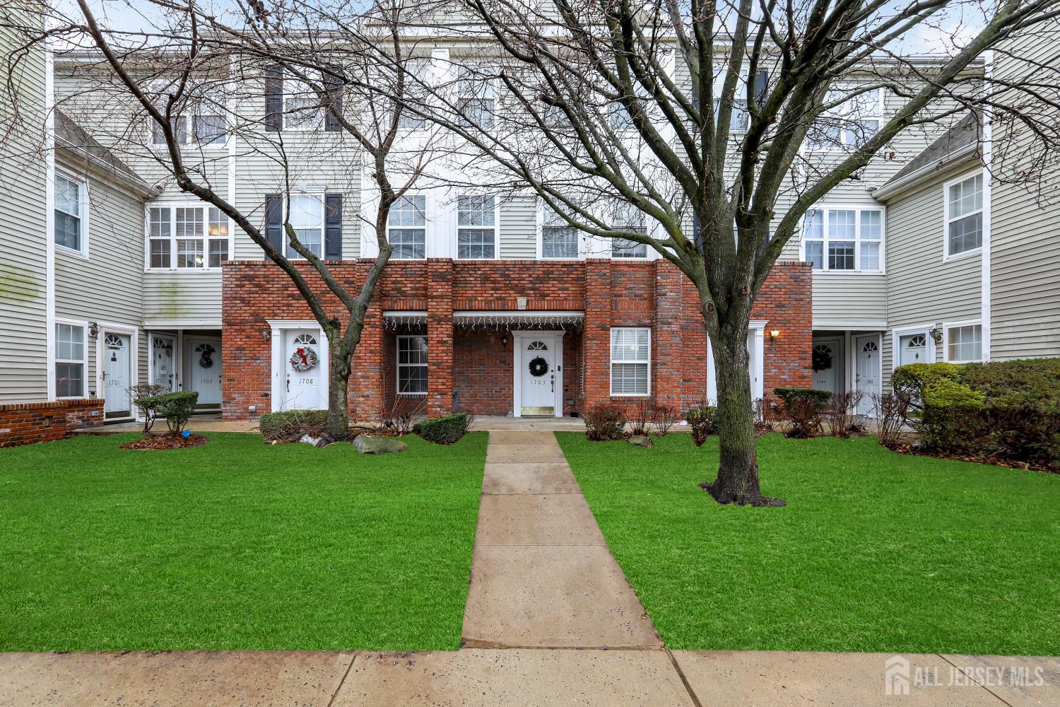 a front view of a house with a garden and trees