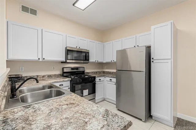 a kitchen with stainless steel appliances granite countertop a refrigerator stove a sink and dishwasher