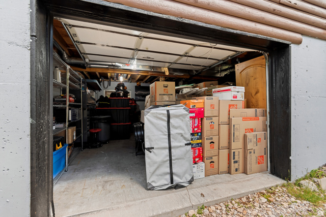 11237 East Aspen Road, Unit 74 Heber City, UT 84032 - Photo 25 of 32 Garage space with concrete flooring, exposed ceiling joists, and a roll-up door