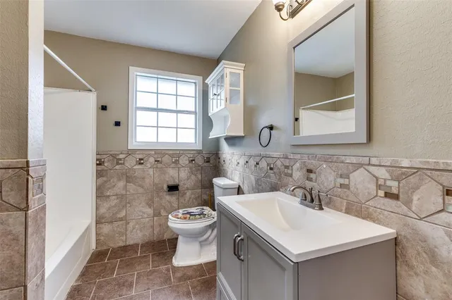 an empty room with wooden floor and ceiling fan