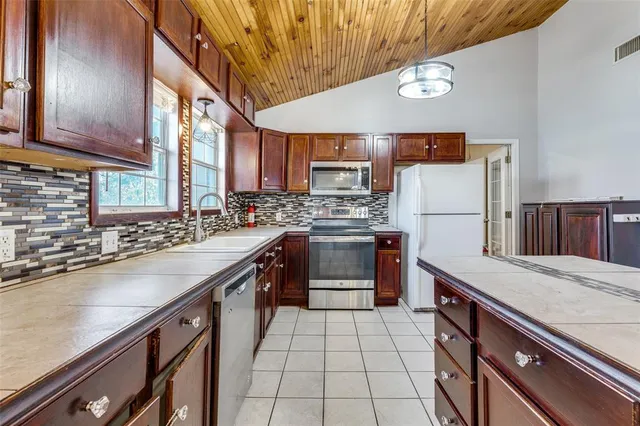 a kitchen with stainless steel appliances granite countertop a stove a sink dishwasher and a refrigerator