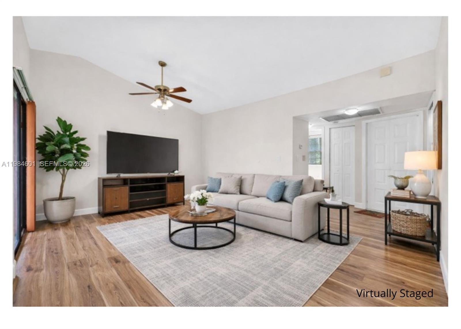 889 Hamilton Drive, Unit 889L Homestead, FL 33034 - Photo 9 of 28 a living room with furniture a flat screen tv and a potted plant