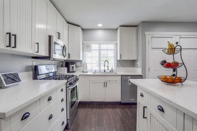 a kitchen with stainless steel appliances granite countertop a stove and a sink