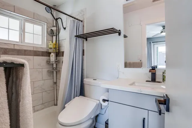 a bathroom with a sink toilet vanity and shower