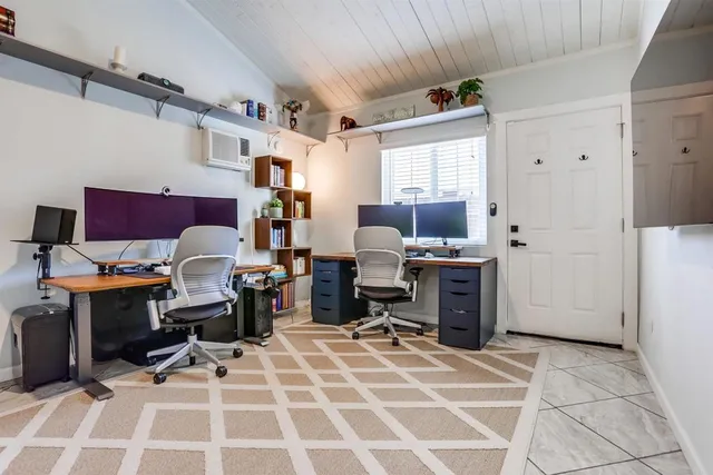 a view of a workspace with furniture and a window