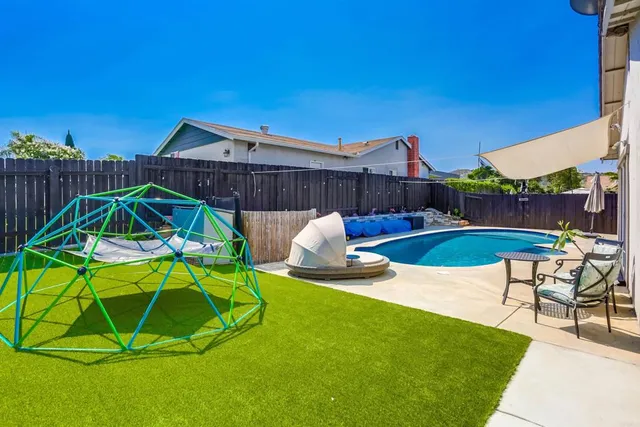a backyard of a house with table and chairs
