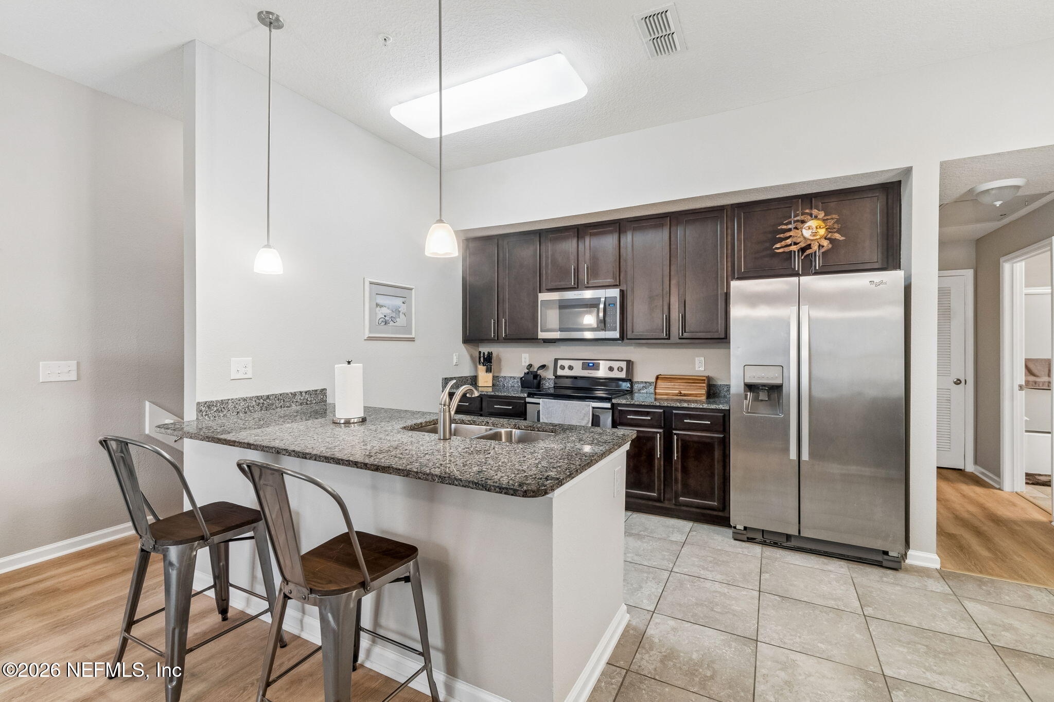 2113 Golden Lake Loop St. Augustine, FL 32084 - Photo 14 of 50 a kitchen with stainless steel appliances granite countertop a stove a refrigerator a sink a dining table and chairs