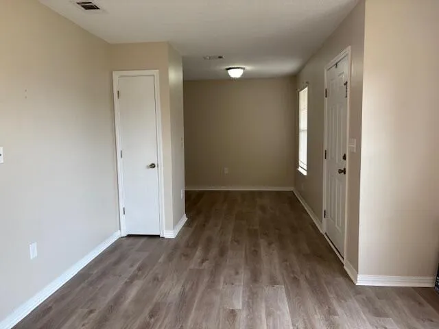 a view of a hallway with wooden floor