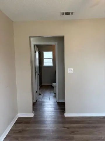 a view of a hallway with wooden floor and closet