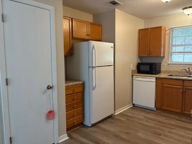 a kitchen with a refrigerator a stove top oven a washer and dryer