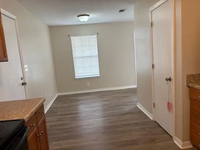a view of a room with wooden floor cabinet and windows