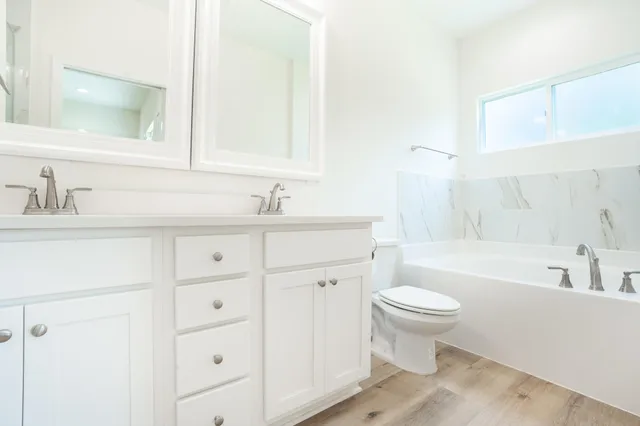a bathroom with a sink toilet vanity and bathtub