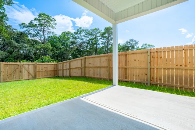 a view of a backyard with wooden fence