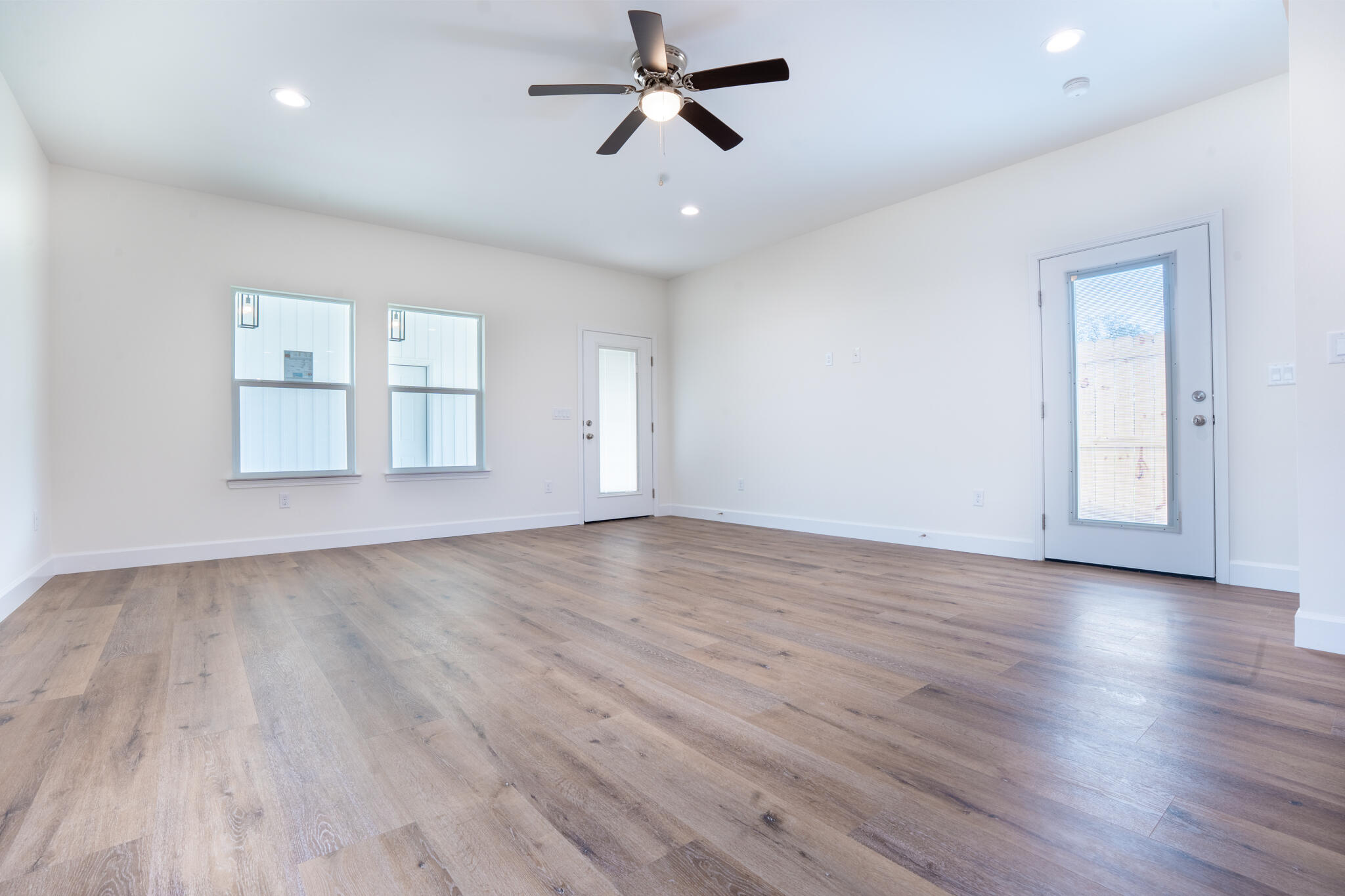 110 2nd Avenue Shalimar, FL 32579 - Photo 6 of 15 an empty room with wooden floor ceiling fan and windows