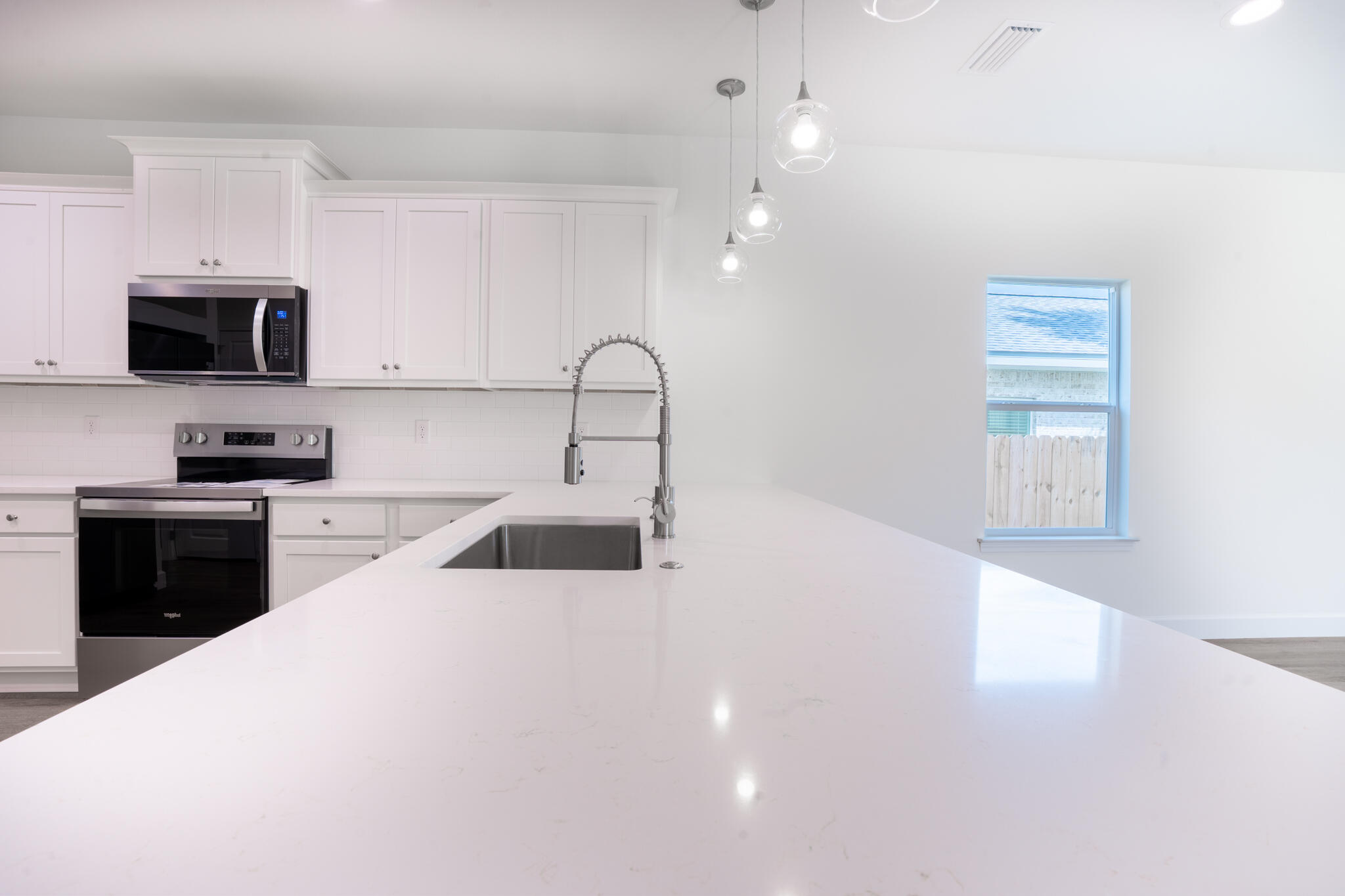 110 2nd Avenue Shalimar, FL 32579 - Photo 8 of 15 a large white kitchen with stainless steel appliances a large counter top a stove a sink and a refrigerator