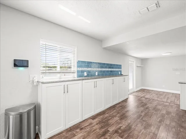 a kitchen with granite countertop white cabinets and white appliances