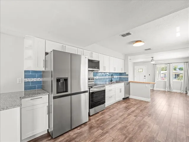 a kitchen with white cabinets and stainless steel appliances