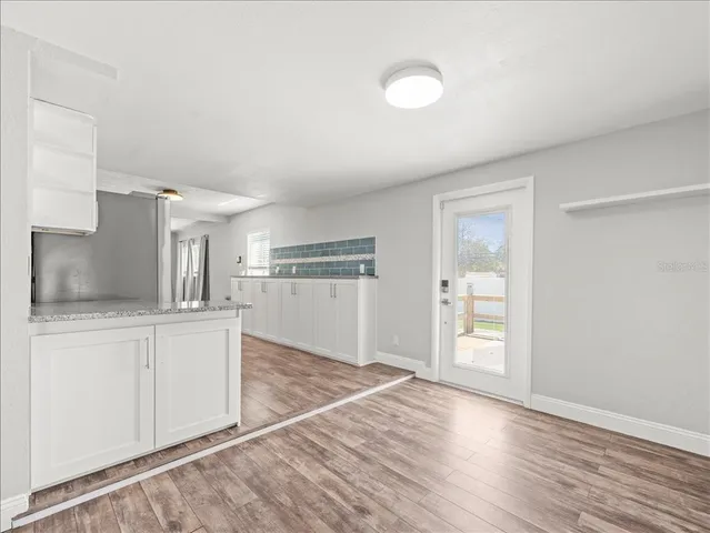a view of a kitchen with wooden floor and a sink
