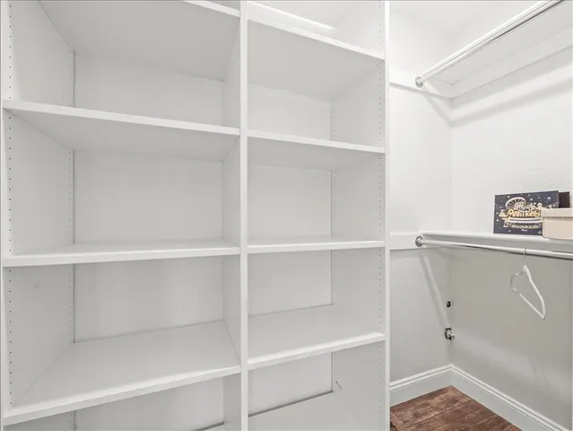 a view of walk in closet with empty racks