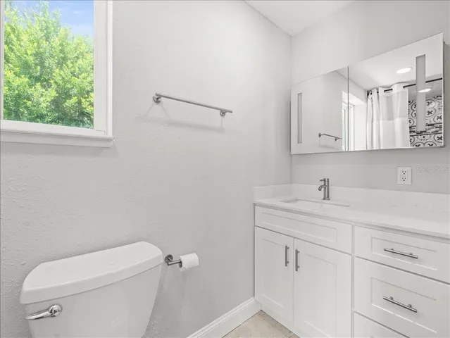 a bathroom with a toilet a sink and mirror